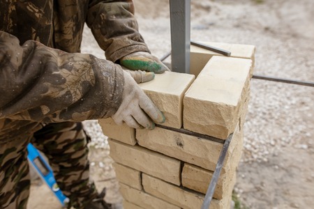 The worker is laying bricks on the fence .の写真素材