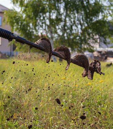 Worker drills the ground for the fence .の写真素材