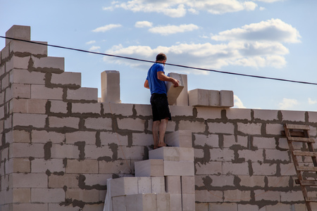 Worker lays bricks at a house construction .の写真素材