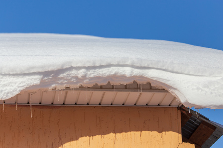 Snow on the roof of the house in winter .の写真素材