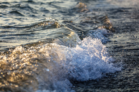 Waves at sea in the rays of sunset .