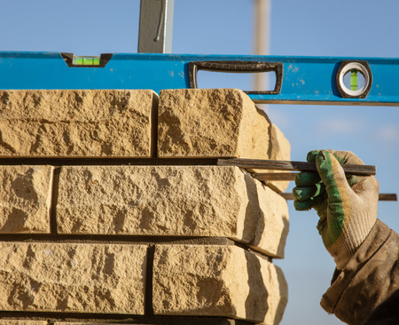 The worker is laying bricks on the fence .の写真素材