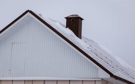Roof of a country house in the snow in winter .