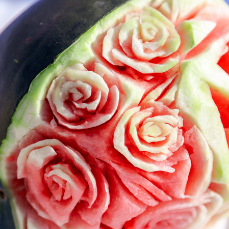 The cook makes a decoration of watermelon with a knife .の写真素材
