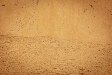 Old wall painted with yellow paint as a background.の写真素材