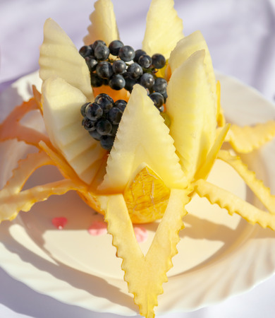 The cook makes a decoration of melon with a knife .の写真素材