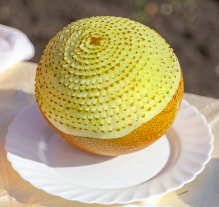 The cook makes a decoration of melon with a knife .の写真素材