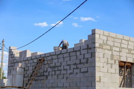 Worker lays bricks at a house construction .の写真素材