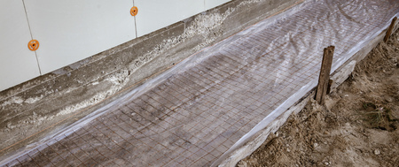 A worker creates a form for pouring concrete.