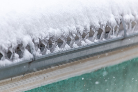 Snow on the roof of the house as a background .