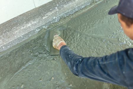 Workers pour concrete solution at a construction site .の写真素材
