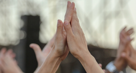 Hands raised up by a man at a concert .の写真素材