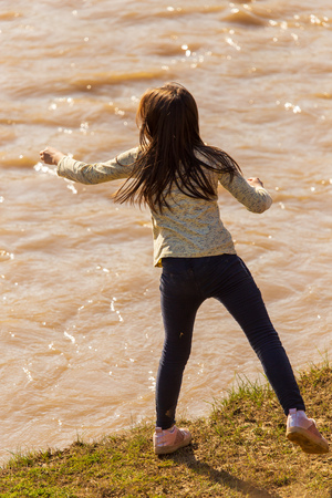 Girl playing on the river bank in nature .の写真素材