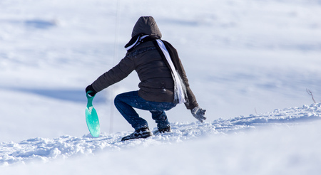 The boy rides a sled from the mountain in winter .