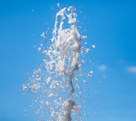 Splashes of water against the blue sky .の写真素材