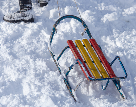 The boy rides a sled from the mountain in winter .の写真素材