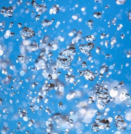 Splashes of water against the blue sky .の写真素材