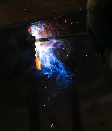 Flame of fire and sparks from welding metal at night .