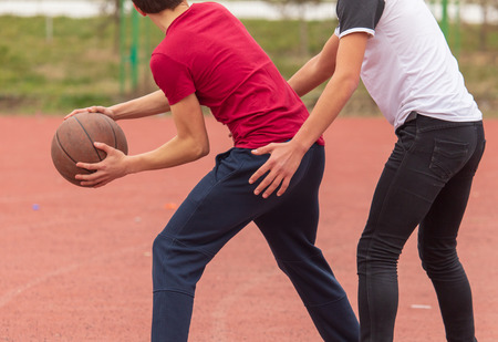 Boys playing basketball with a ball in the park .の写真素材