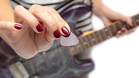 Girl playing an electric guitar on white background .の写真素材