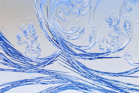 Snow patterns on glass as an abstract background .