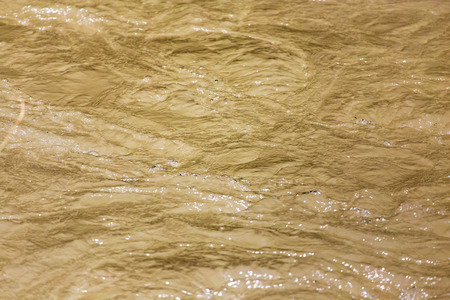 Dirty water in a turbulent river as background .