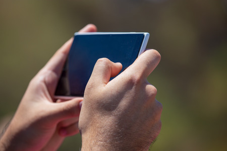 Phone in hand shoots a photo in nature .