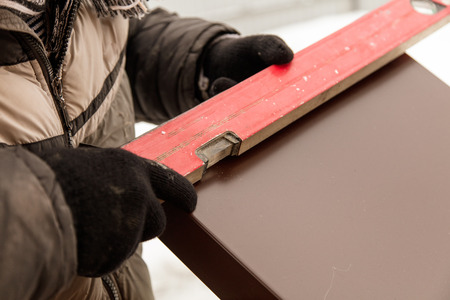 Worker mounts brown metal on the windows .