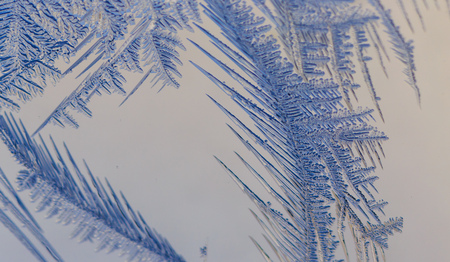 Snow patterns on glass as an abstract background .