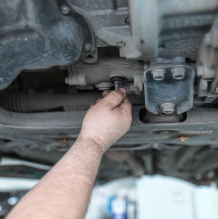 Changing the oil in the car box in the workshop .の写真素材