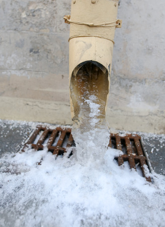 Frozen water from the sewer pipe on the house .の写真素材