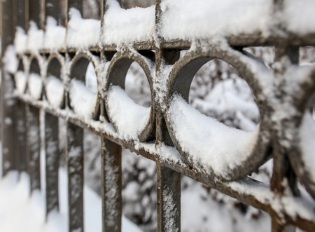 Snow on a metal fence as a background.の写真素材