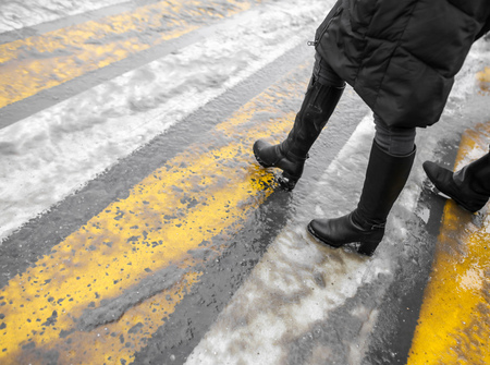 Feet of people at a pedestrian crossing in winter .の写真素材