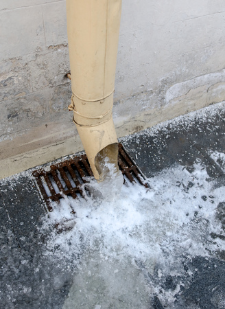 Frozen water from the sewer pipe on the house .