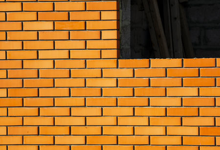 A window in a brick house under construction .