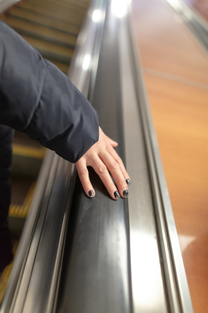 Girl's hand on the escalator in the subway .の写真素材