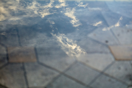Puddle on the road with reflection .