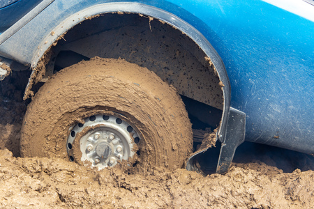 Car wheel slips in the dirt in nature .
