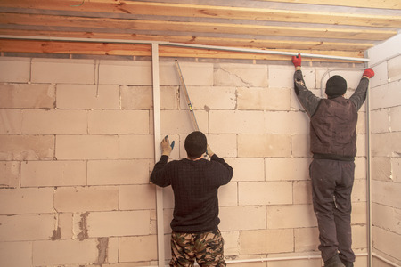 Worker mounts a profile on a wall at a construction site .の写真素材