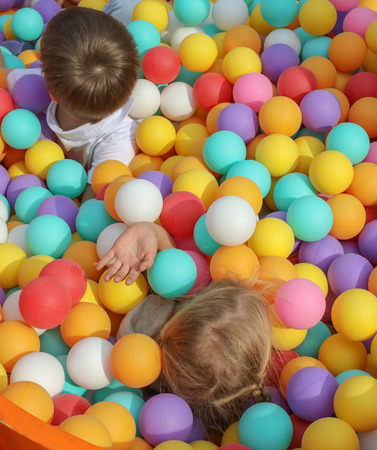 Boy and girl playing in colorful balls on attraction .の写真素材