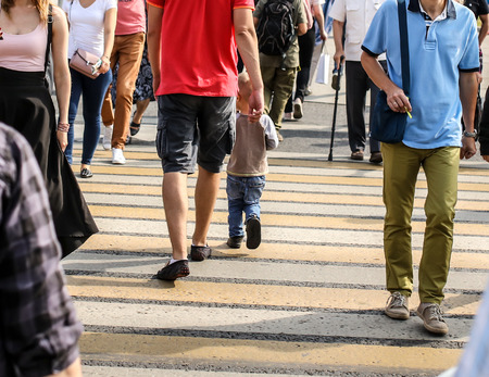 People in the city cross the road at a pedestrian crossing .の写真素材