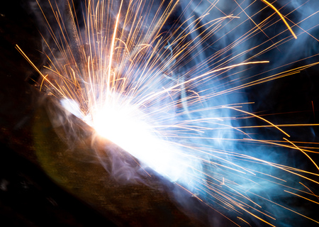 Sparks from welding at a construction site as a background.