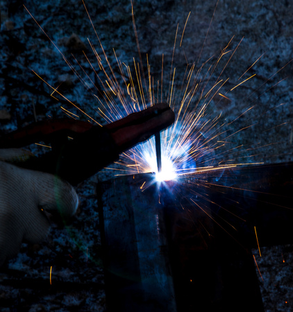 Sparks from welding at a construction site as a background.