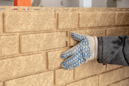 Installing brick siding on the wall of the house .の写真素材