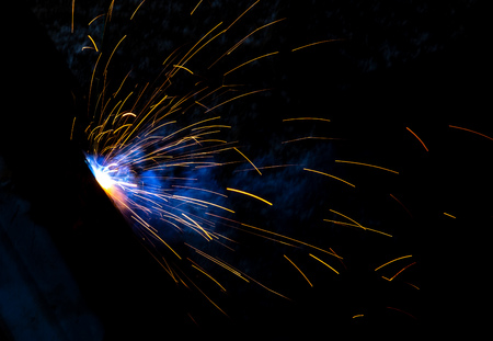 Sparks from welding at a construction site as a background.