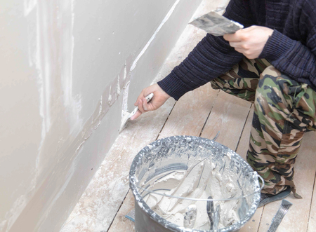 Worker aligns the walls with plaster. Repair in the house.の写真素材