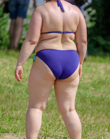 Fat woman in swimsuit on the beach.の写真素材