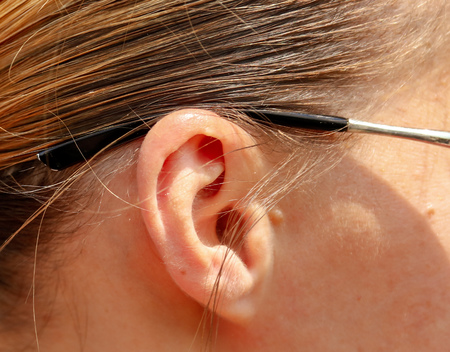 Woman's ear with glasses on her head. Macroの写真素材