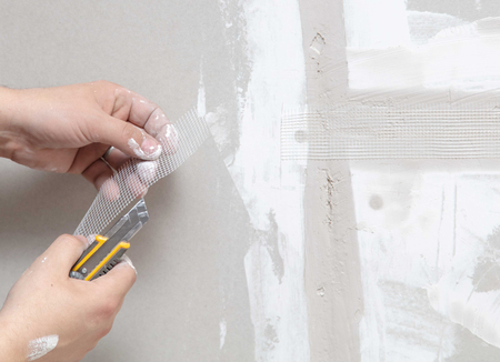 Worker aligns the walls with plaster. Repair in the house.