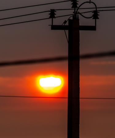 Electric pole at sunset as background.の写真素材